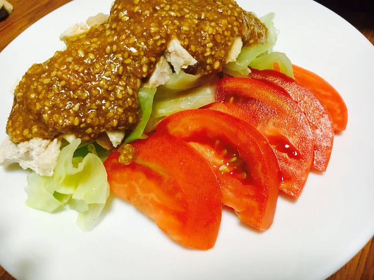 Bon bon chicken with sesame sauce and sliced tomatoes and lettuce on side