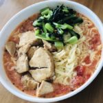 Tomato Ramen with chicken and spinach as toppings