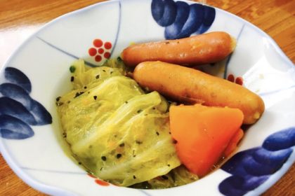 Cooked ground meat wrapped by cabbage leaves. Served with cooked weiner and carrots.