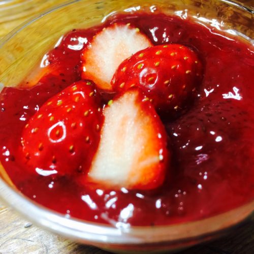 Milk pudding covered with strawberry sauce on top.