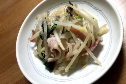 Bacon, bean sprouts, and spinach stir fry on a plate